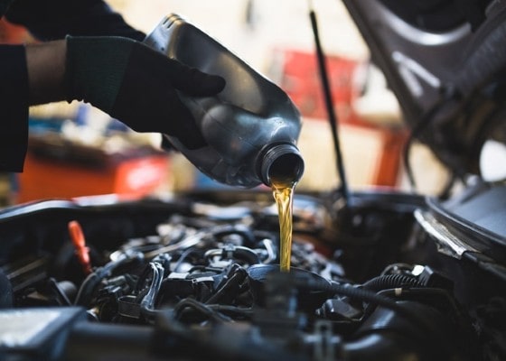 Engine oil being poured into a car engine during maintenance at Philips Auto & Tires.
