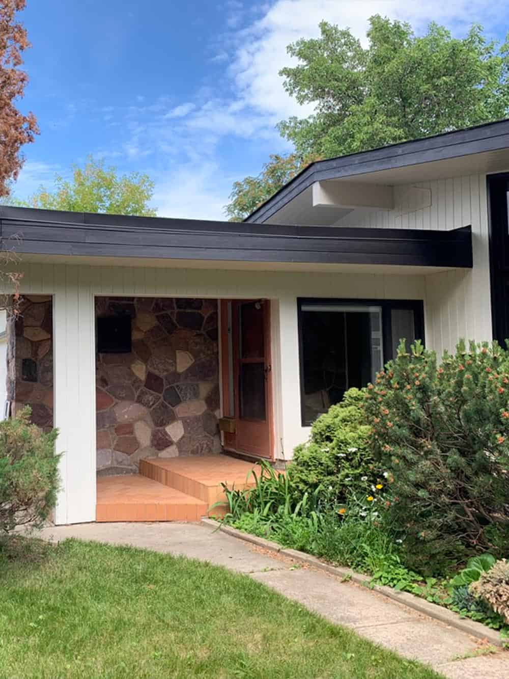 Charming home entrance with greenery.
