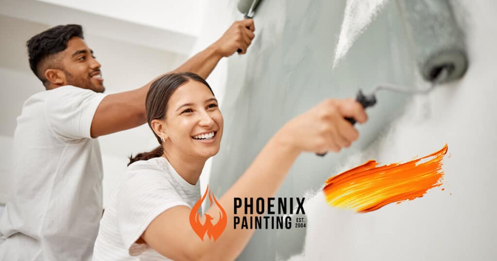 Two people painting a wall together.