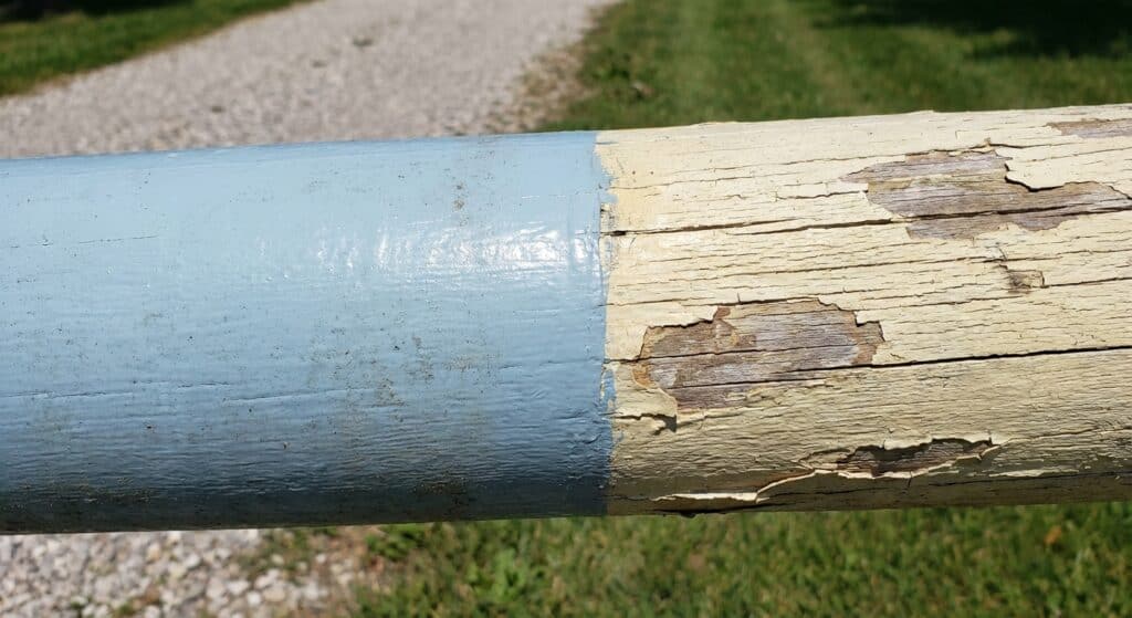 Old wooden bench with chipped paint, weathered surface, and signs of aging in a scenic outdoor park.