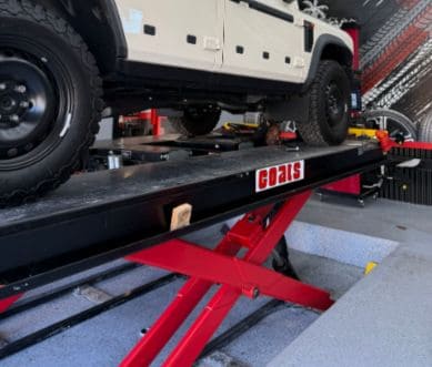 Vehicle on wheel alignment lift at Pittstop Auto Care for precise vehicle diagnostics.