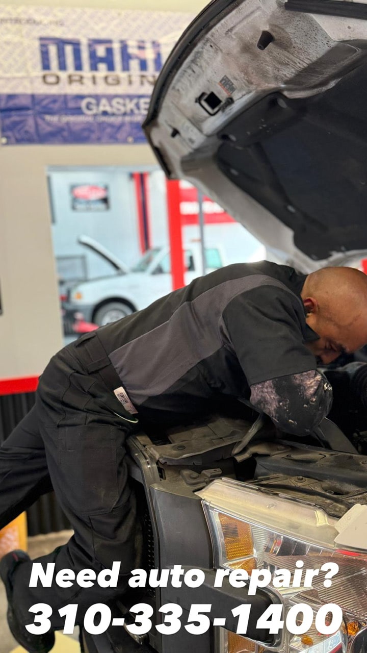 Auto mechanic inspecting engine in repair shop at Pittstop Auto Care.