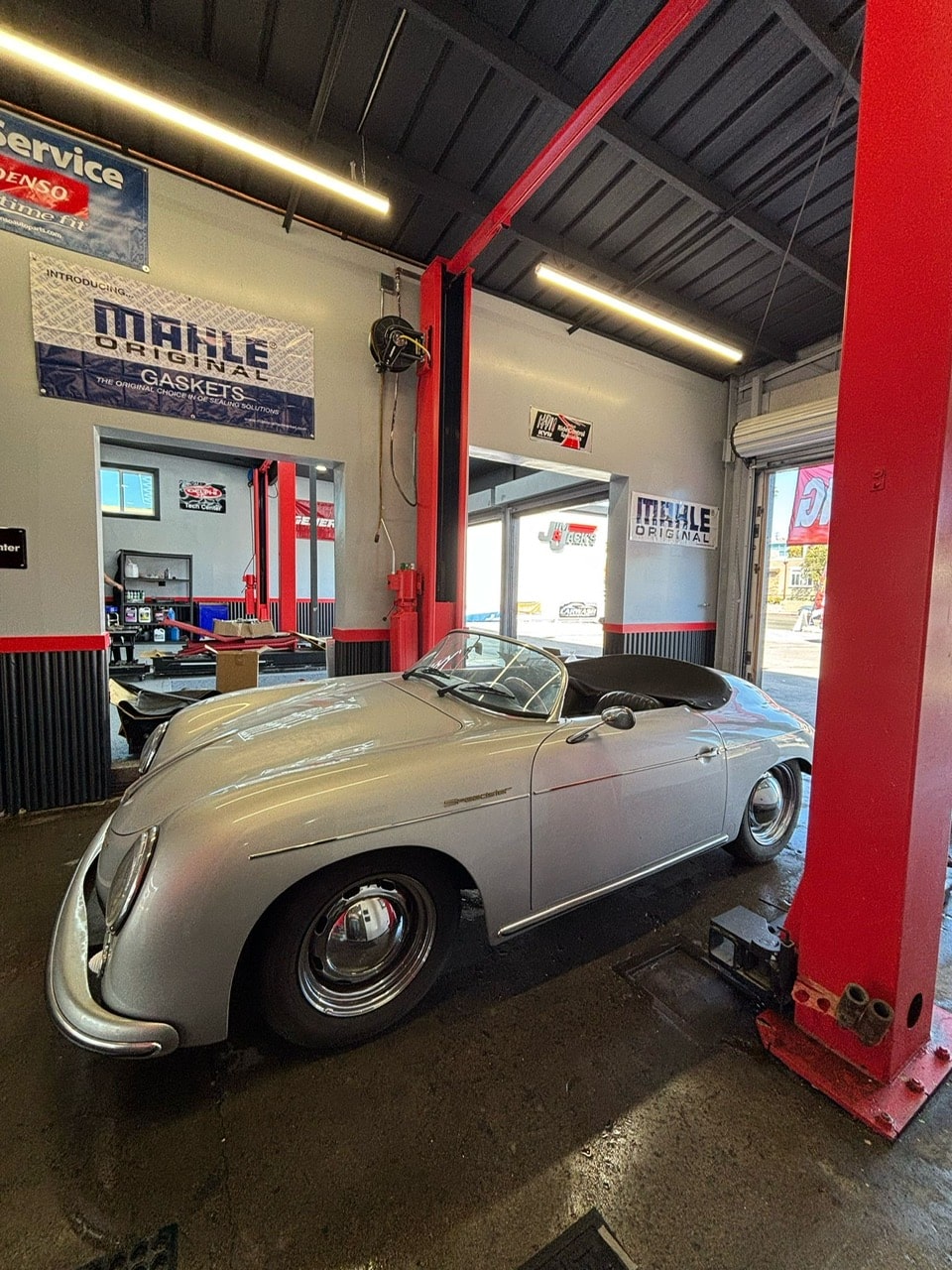Classic silver convertible car inside Pittstop Auto Care garage, showcasing auto repair and maintena.