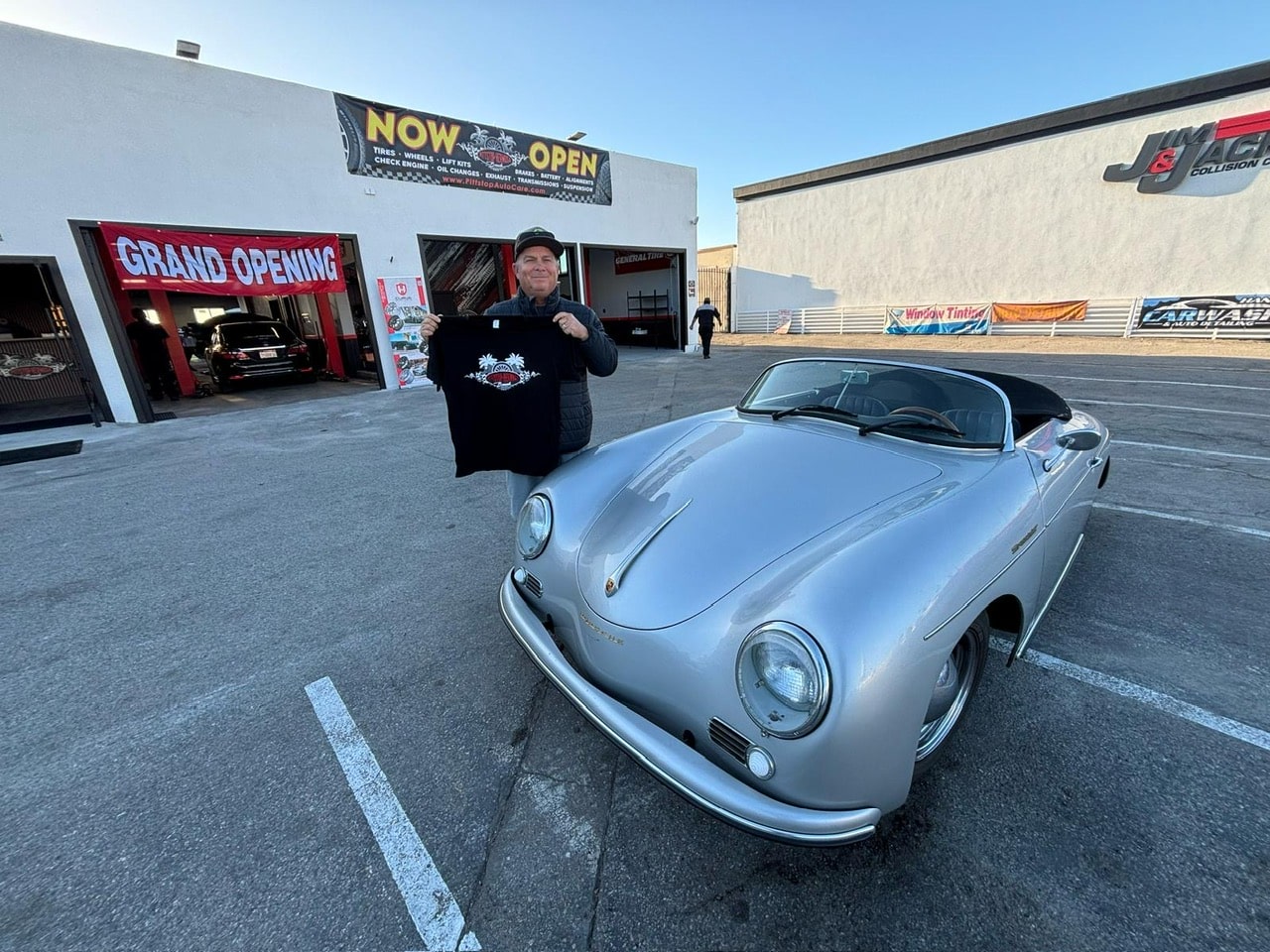 Vintage sports car parked outside Pittstop Auto Care during grand opening celebration.