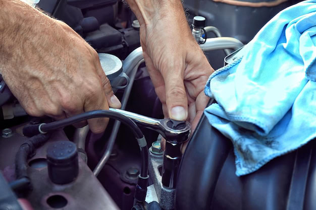Auto mechanic inspecting engine components during vehicle repair.