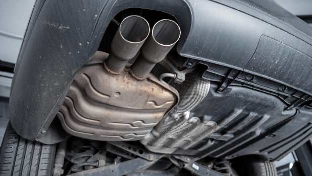 Exhaust system and muffler of a car viewed from underneath.
