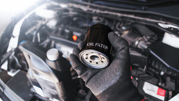 Oil filter being replaced during vehicle maintenance at Johnny’s Automotive. Expert auto services fo.