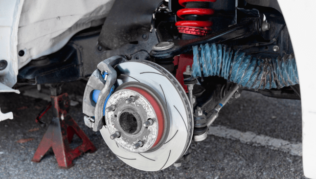 Close-up of car brake system with disc brake and suspension components.