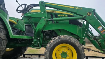 Green John Deere tractor with front loader for towing and heavy-duty work.