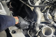 Skilled mechanic working on car engine at Johnny’s Automotive repair shop.