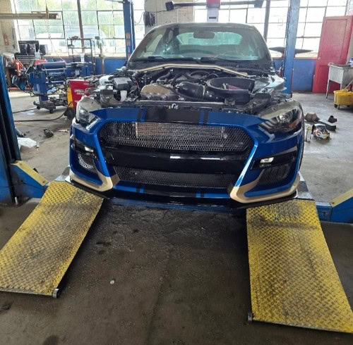 Blue sports car on repair lift at Johnny's Automotive, contact us for auto repair services.
