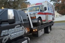 Emergency vehicle towing, flatbed truck, Johnny’s Automotive, roadside assistance.