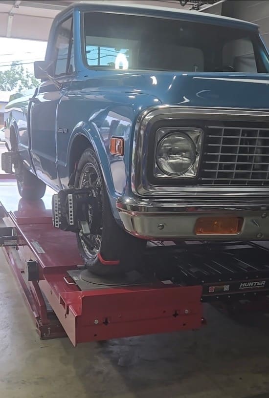 Blue vintage pickup truck on alignment rack at POPS FULL SERVICE.