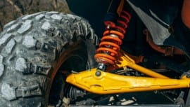 Close-up of off-road vehicle suspension and tire for rugged terrain.