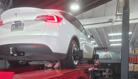 Auto repair service with a white car on a hydraulic lift at POPS FULL SERVICE.
