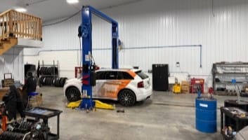 Auto repair shop with technicians working on a vehicle.