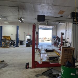 Auto repair shop with vehicle lift and tools.