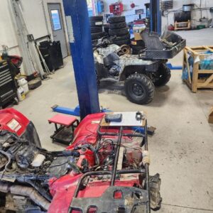 Auto repair shop with utility vehicles, tools, and equipment for engine repairs.