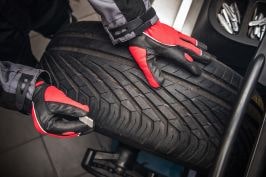 Technician performing tire rotation on a vehicle for optimal tire wear and safety.