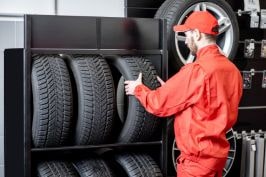Customer inspecting a tire at a tire shop, showcasing premium tire options.