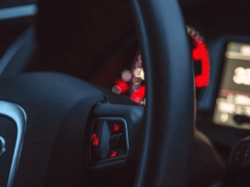 Auto repair steering wheel with dashboard display in the background.
