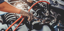 Technician performing maintenance on a vehicle engine for fleet services.