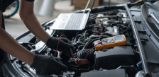 Technician performing maintenance on a vehicle engine for fleet services.
