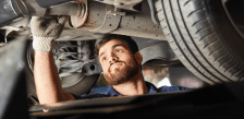 Skilled technician performing in-shop fleet repair on commercial vehicle.