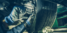 Fleet technician inspecting a vehicle tire for maintenance.