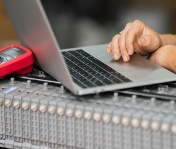 Technician using a laptop for fleet service diagnostics and management.