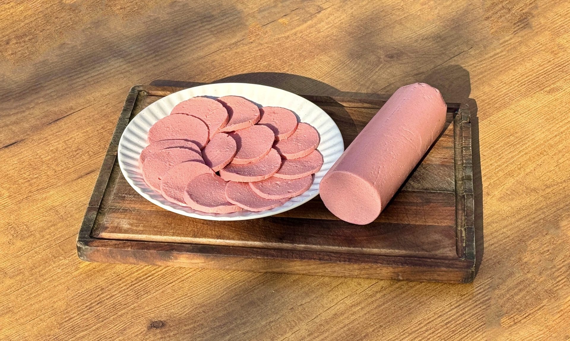 GARDENELA 50g, kalibrisana šunka na tanjiru, prikaz na drvenom stolu.