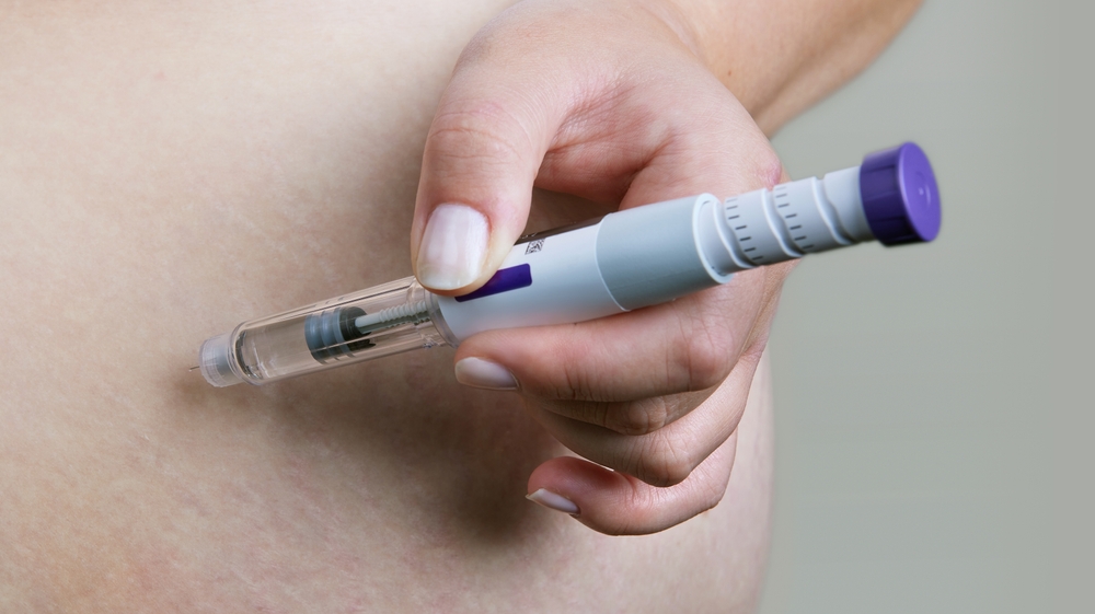 Close-up of a person administering Tirzepatide injection for medical weight loss treatment, highlighting innovative approaches at Renovo Health and Beauty.