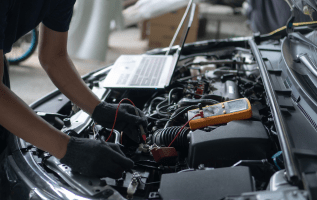 Technician repairing car engine at Rob & Son Garage.