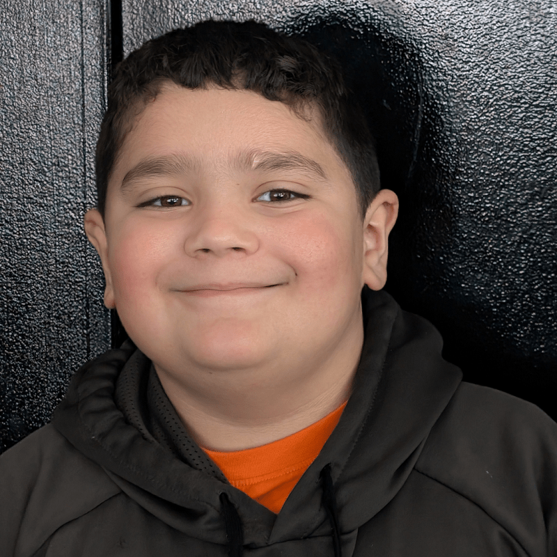 Young boy smiling at Rob & Son Garage, showcasing friendly service and community trust.