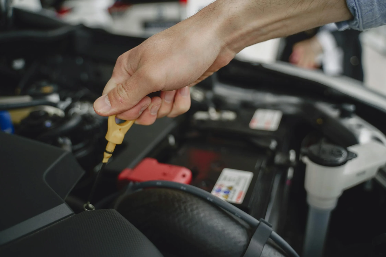 Technician performing an oil change on a vehicle engine at Rob & Son Garage.
