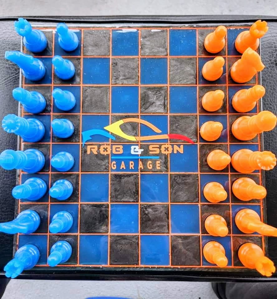 Merchandise chess game with branded pieces at Rob & Son Garage.
