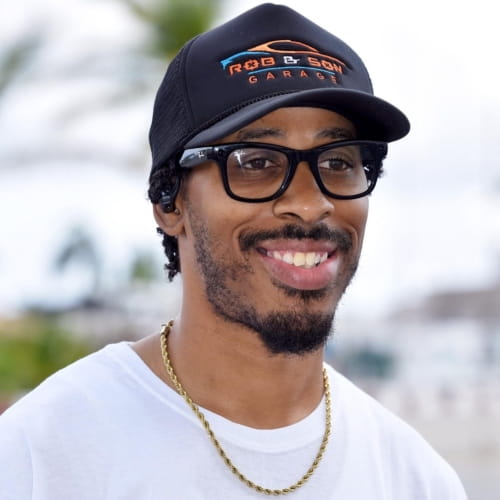 Car service technician wearing a cap and glasses at Rob & Son Garage.