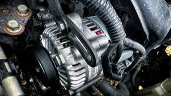 Close-up of car engine showing belts and pulleys at Rob's Auto Repair.