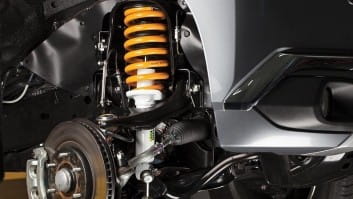 Close-up of a car suspension system with coil spring and shock absorber.