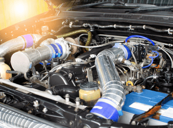 Close-up of a modern car engine with turbocharger components at Sam's Auto Repair.