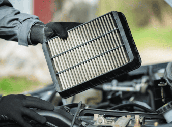 Auto air filter being replaced in a vehicle engine.