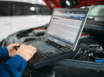 Auto repair diagnostic testing under the hood of a vehicle.