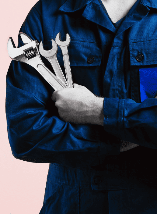 Auto repair technician holding wrenches and spanners.