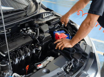 Auto repair technician inspecting engine components.