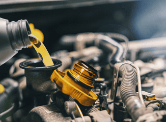 Mechanic pouring engine oil during vehicle maintenance at Sam's Auto Repair.