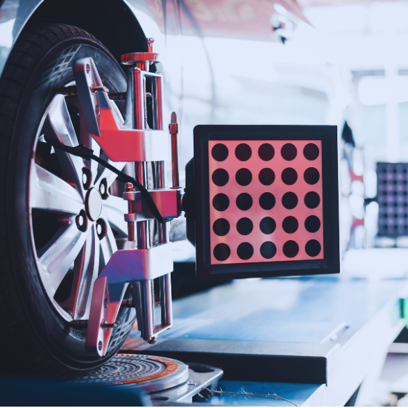 Car wheel being aligned with precision equipment at Sam's Auto Repair.