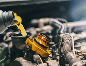 Car engine oil being poured during an auto repair service.