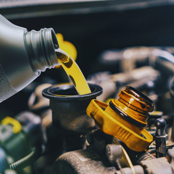 Pouring fresh oil into a car engine during an oil change at Sam's Auto Repair.