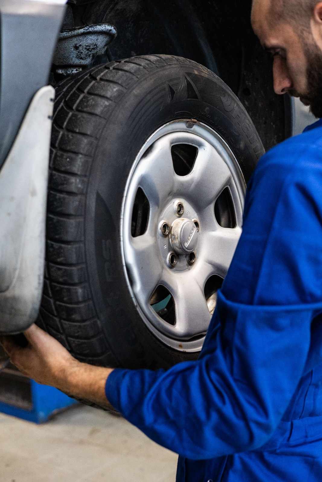 Technician inspecting a vehicle's tire at Sanfelippo Auto Repair.