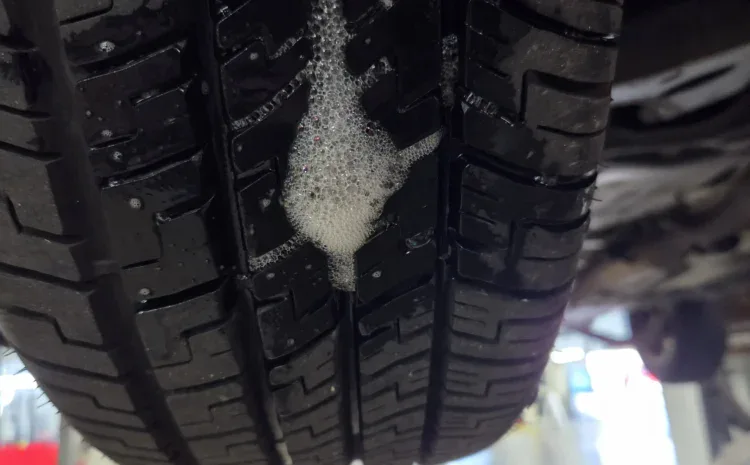 Tire tread close-up at Sanfelippo Auto Repair header with soapy residue.